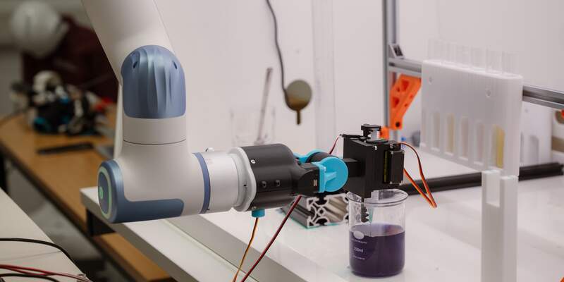 robot holds a syringe over a beaker